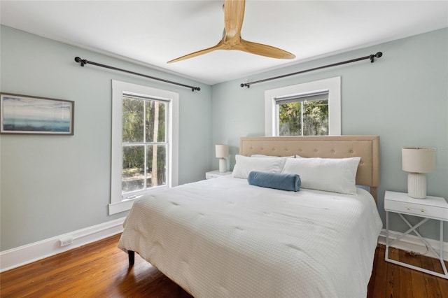 bedroom with dark hardwood / wood-style floors and ceiling fan