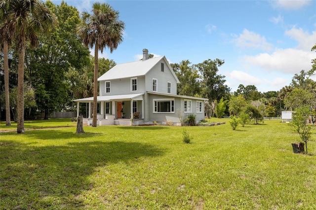 back of house featuring a lawn and a porch