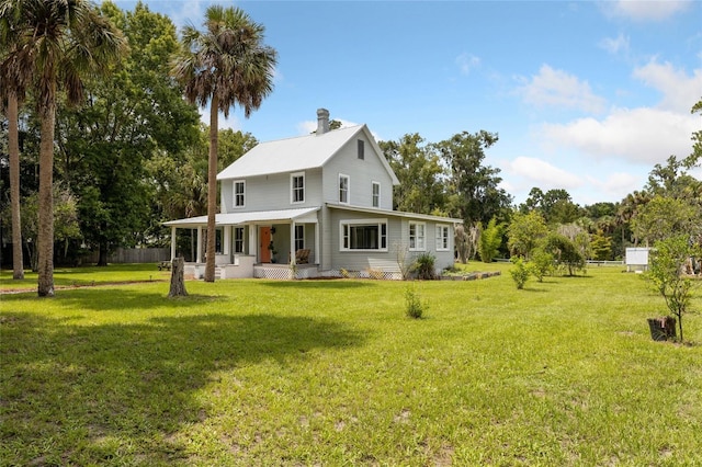 back of property featuring a yard, fence, and covered porch