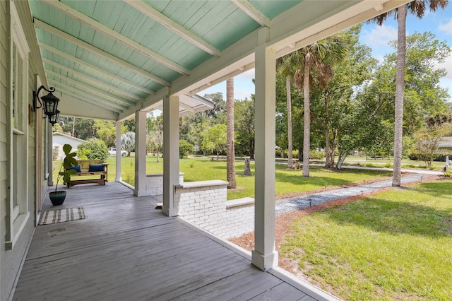 wooden terrace with a yard and covered porch