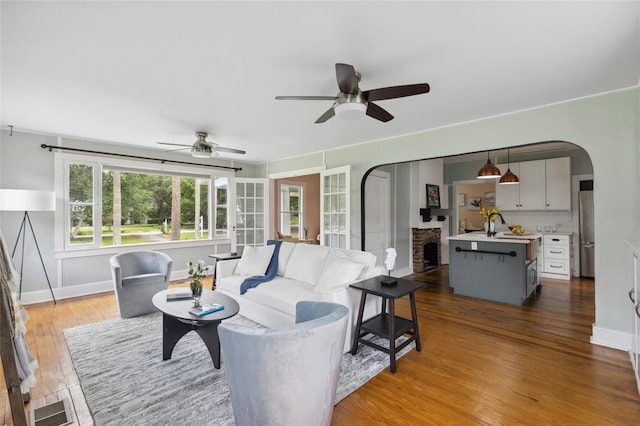 living room featuring ceiling fan, a fireplace, and light hardwood / wood-style flooring