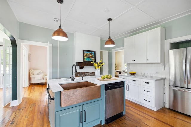 kitchen featuring white cabinetry, sink, light hardwood / wood-style floors, and appliances with stainless steel finishes