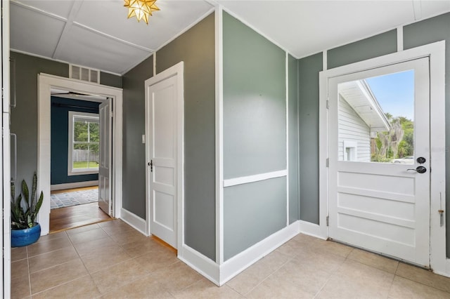 foyer with a skylight, a wealth of natural light, and light tile patterned floors