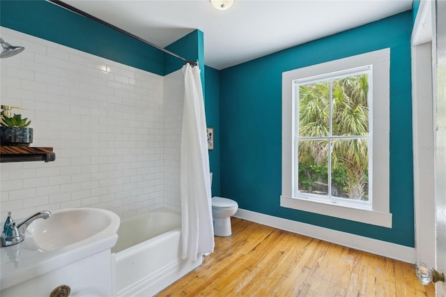 bathroom featuring shower / bath combination with curtain, toilet, and wood-type flooring