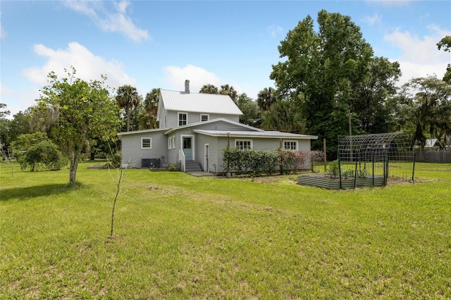 rear view of property with a yard and central air condition unit