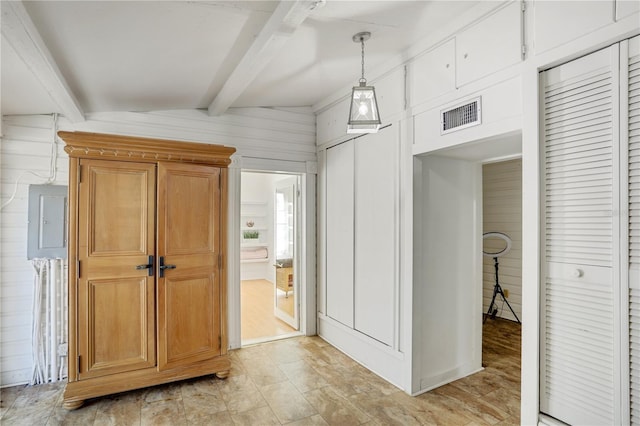 interior space featuring electric panel, beamed ceiling, and wood walls