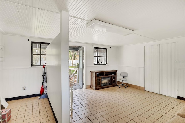 unfurnished living room with a multi sided fireplace and light tile patterned floors