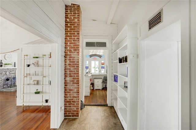 corridor featuring beamed ceiling and wood-type flooring