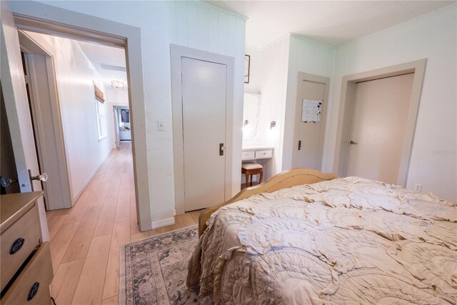 bedroom with crown molding and light hardwood / wood-style flooring