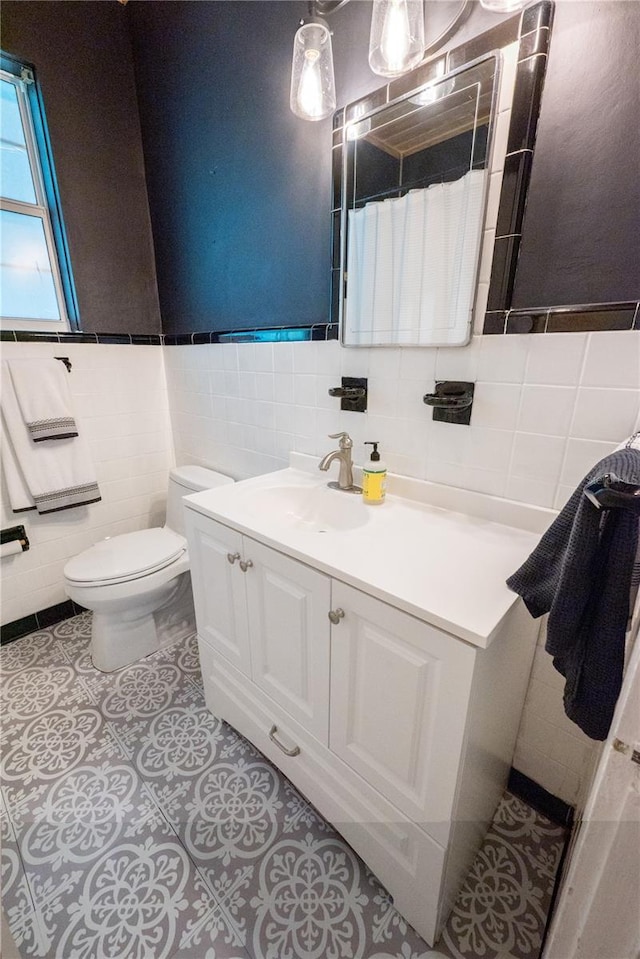 bathroom with vanity, tile walls, tile patterned floors, and toilet