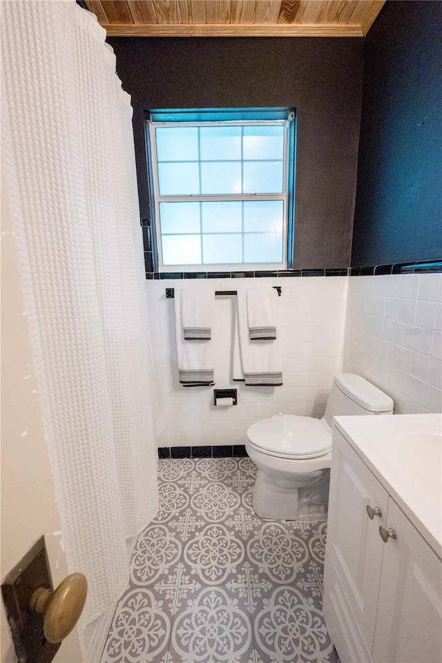 bathroom with vanity, tile patterned floors, tile walls, wooden ceiling, and toilet