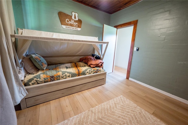 bedroom with hardwood / wood-style floors and wood ceiling