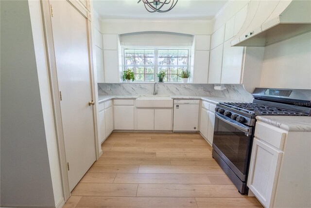 kitchen featuring custom range hood, white cabinets, dishwasher, stainless steel range with gas stovetop, and sink