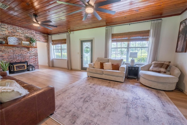 living room featuring a healthy amount of sunlight, brick wall, light hardwood / wood-style flooring, a brick fireplace, and wood ceiling