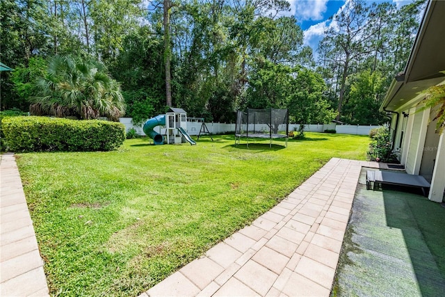 view of yard featuring a patio, a playground, and a trampoline