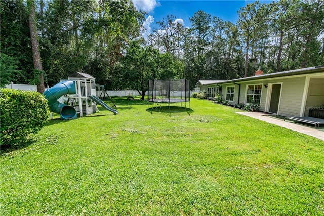 view of yard featuring a trampoline and a playground