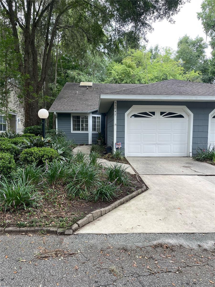 view of front facade featuring an attached garage, a shingled roof, and concrete driveway