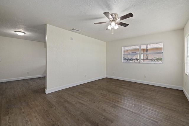 empty room with a textured ceiling, ceiling fan, and dark hardwood / wood-style floors