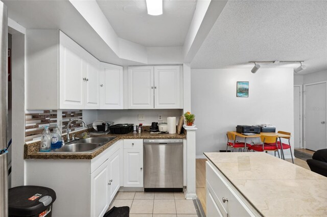 kitchen featuring white cabinetry, dishwasher, light tile patterned floors, and sink