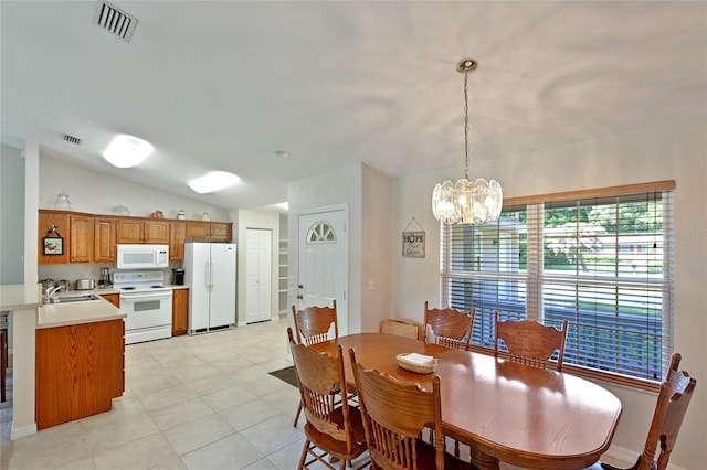 tiled dining area featuring sink, vaulted ceiling, and a chandelier