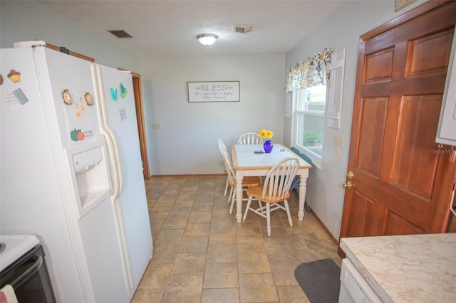 kitchen with white cabinetry, range with electric stovetop, and white fridge with ice dispenser