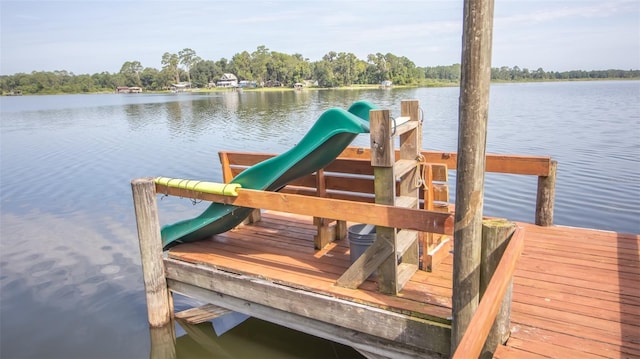 view of dock featuring a playground and a water view