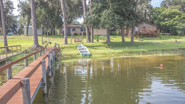 dock area with a water view and a yard