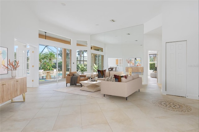 living room with light tile patterned floors and a high ceiling