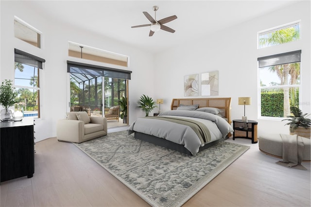 bedroom with wood finished floors, a ceiling fan, and access to exterior