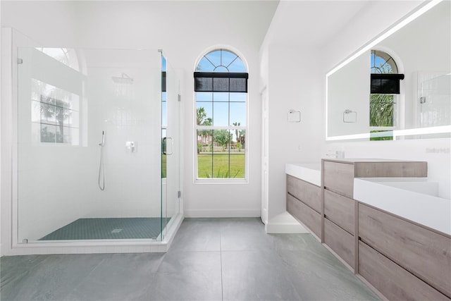 bathroom featuring tile patterned floors, vanity, and a shower with door