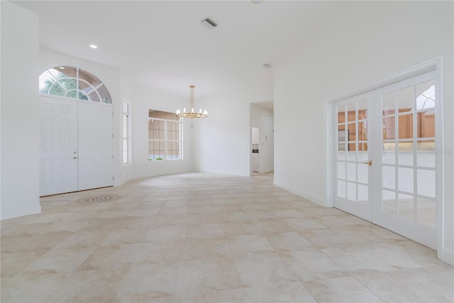 foyer featuring a wealth of natural light, french doors, visible vents, and a chandelier