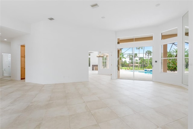 unfurnished room featuring a high ceiling, light tile patterned floors, and visible vents