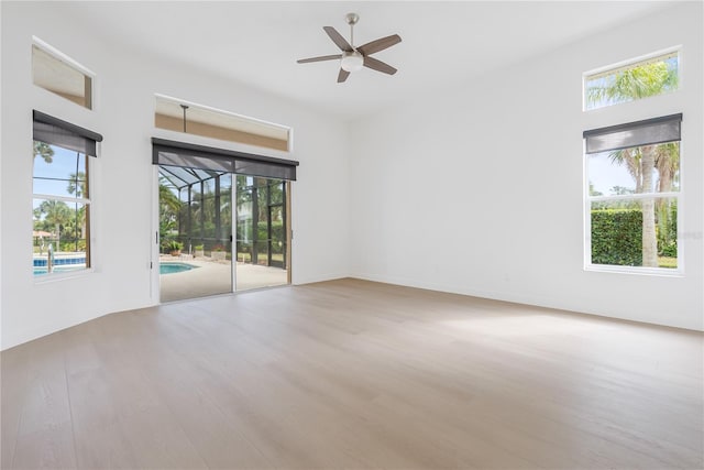 spare room featuring a wealth of natural light, light hardwood / wood-style flooring, and ceiling fan