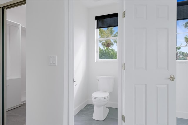 bathroom with toilet and baseboards