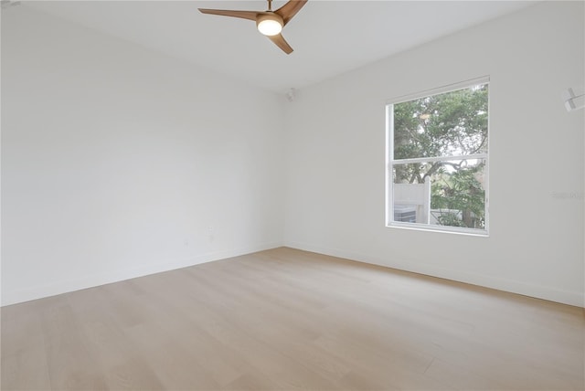 unfurnished room featuring baseboards, light wood-style floors, and a ceiling fan