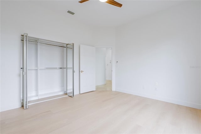 unfurnished bedroom featuring ceiling fan, a closet, and light hardwood / wood-style flooring