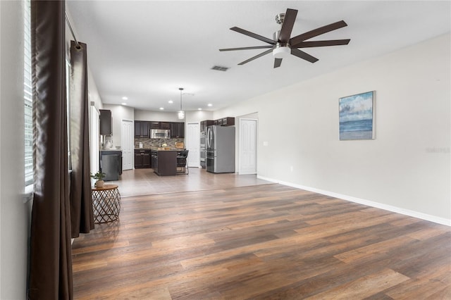 unfurnished living room with ceiling fan and hardwood / wood-style floors