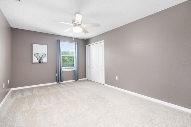 carpeted spare room with ceiling fan