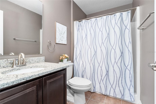 bathroom featuring a textured ceiling, vanity, tile patterned flooring, and toilet