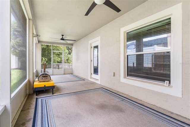 unfurnished sunroom featuring ceiling fan