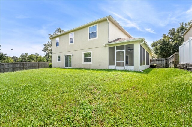 back of house with a lawn and a sunroom