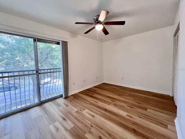 spare room with ceiling fan, wood finished floors, and baseboards