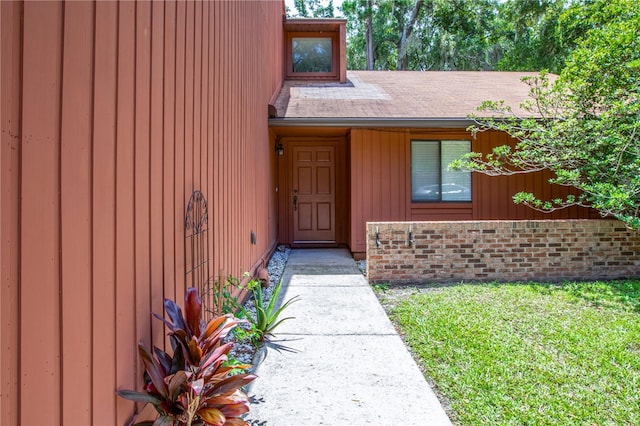 view of exterior entry featuring a lawn