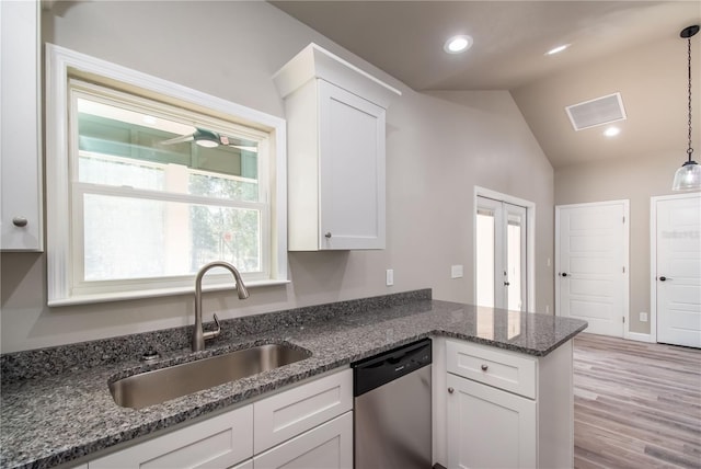 kitchen featuring sink, stainless steel dishwasher, lofted ceiling, white cabinets, and pendant lighting