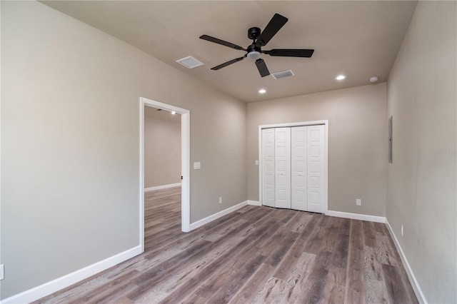 unfurnished bedroom with wood finished floors, recessed lighting, a closet, baseboards, and a ceiling fan