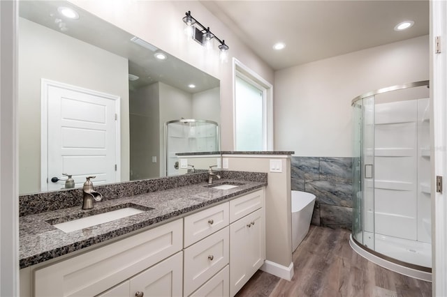 bathroom with tile walls, shower with separate bathtub, hardwood / wood-style flooring, and vanity