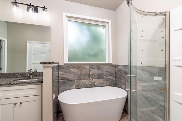 bathroom featuring vanity, shower with separate bathtub, and tile walls