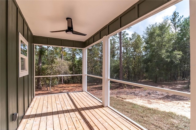 unfurnished sunroom featuring ceiling fan