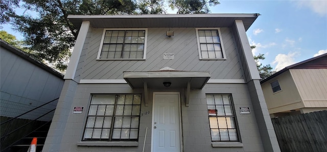 view of front of property featuring fence and concrete block siding