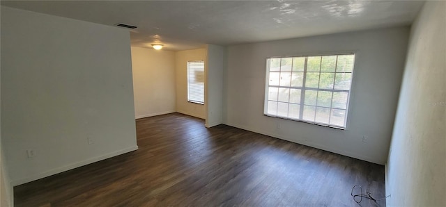 spare room featuring dark wood-style floors, baseboards, and visible vents